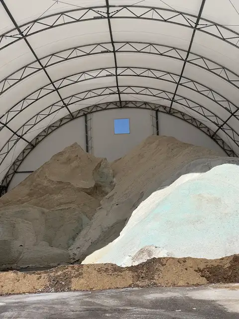 Massive piles of grit under an arching canopy.